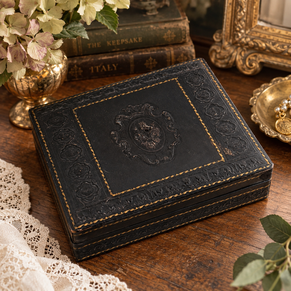 Styled vintage Italian Florentine leather jewelry box with antique books and brass decor